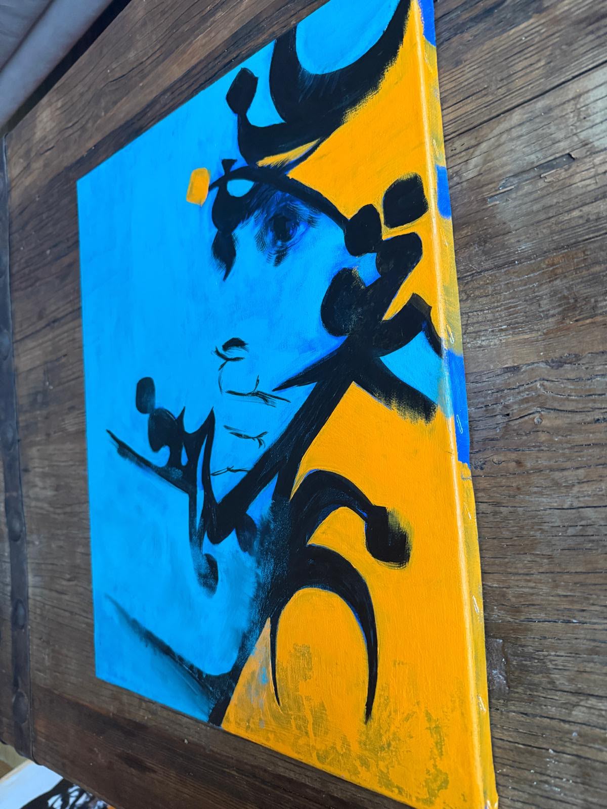 Black calligraphy on blue and yellow canvas