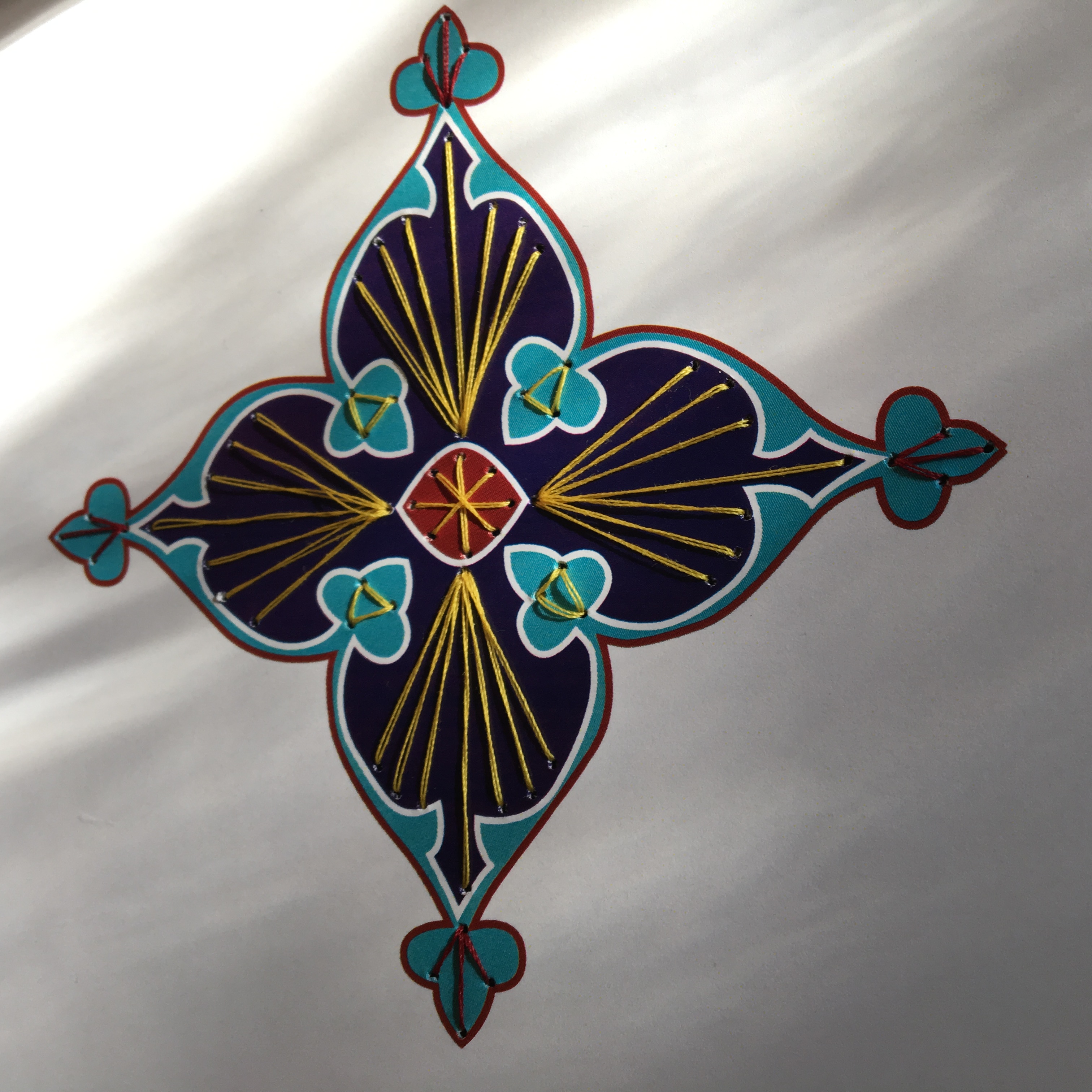 Embroidered illuminated medallion in indigo, teal and gold