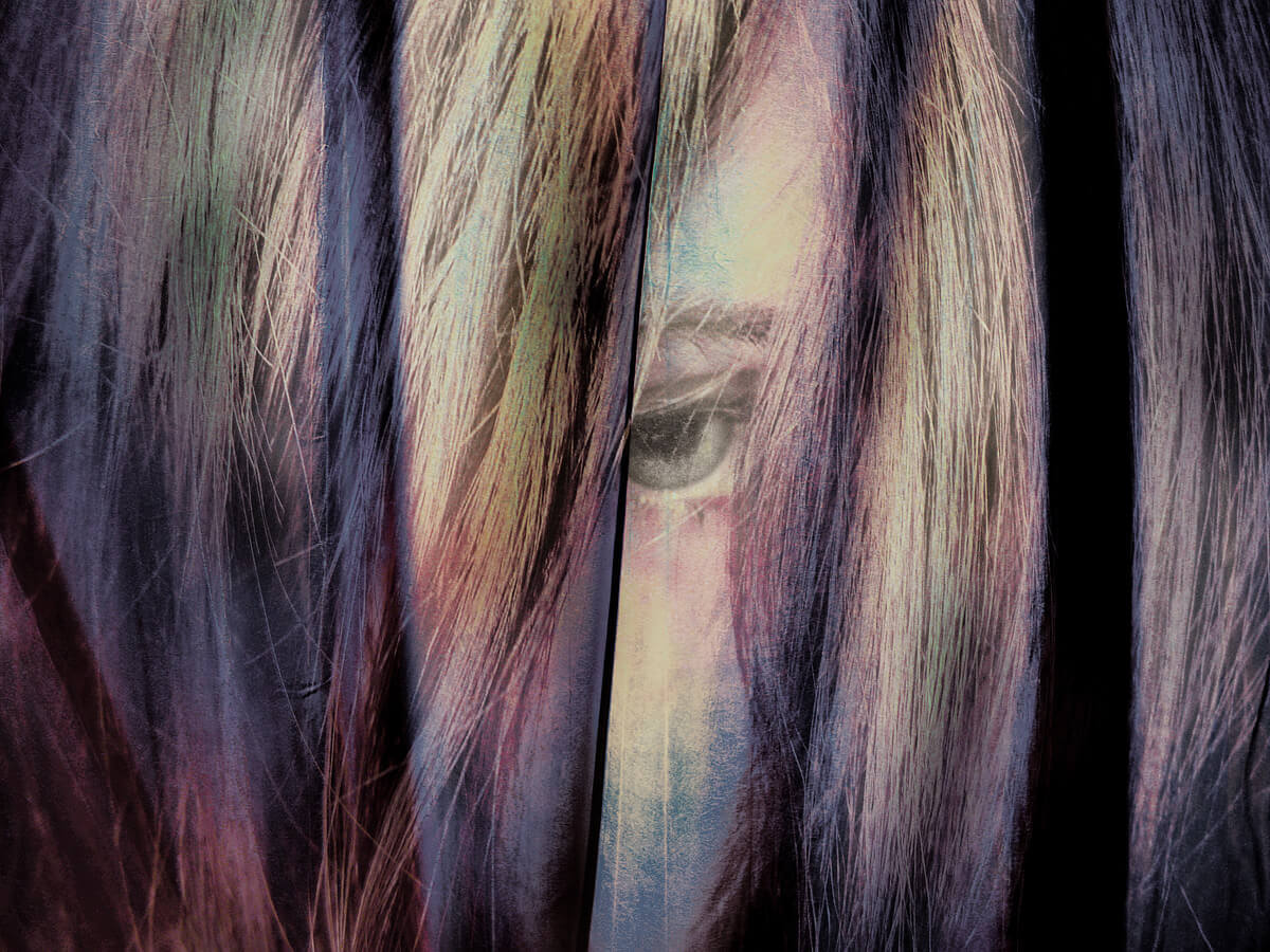 Eye visible between strands of hair